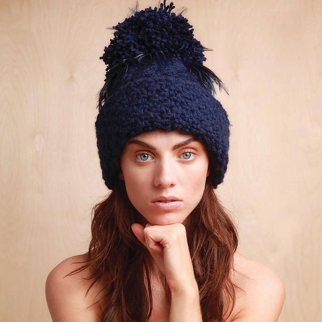 Navy Hand Knit Irish Aran Beanie Hat with Mega Pom Pom, adorned with Davina's signature Feather Trim, part of Davina's Award Winning LynchMob Hats Beanie Collection